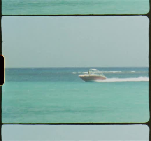 Boat driving on the blue clear ocean water caught on vintage film