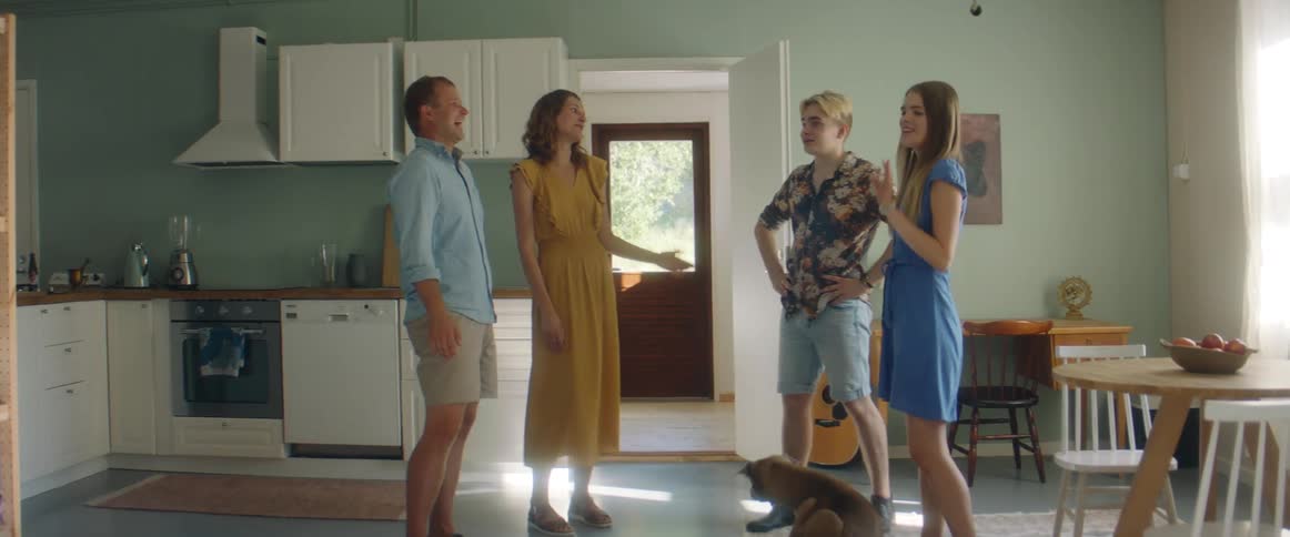 A family are talking with the dog walking around