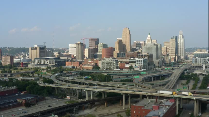 Cars and trucks travel on an overpass in the city under a blue sky