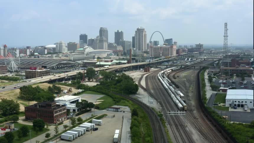 A city sprawls along side several railroad tracks