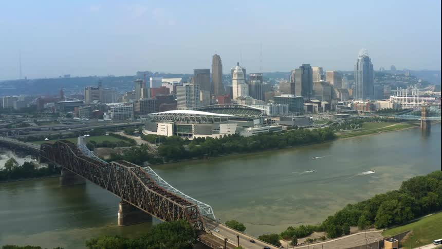 An aerial view of a river flowing through a city with skyscrapers in the distance