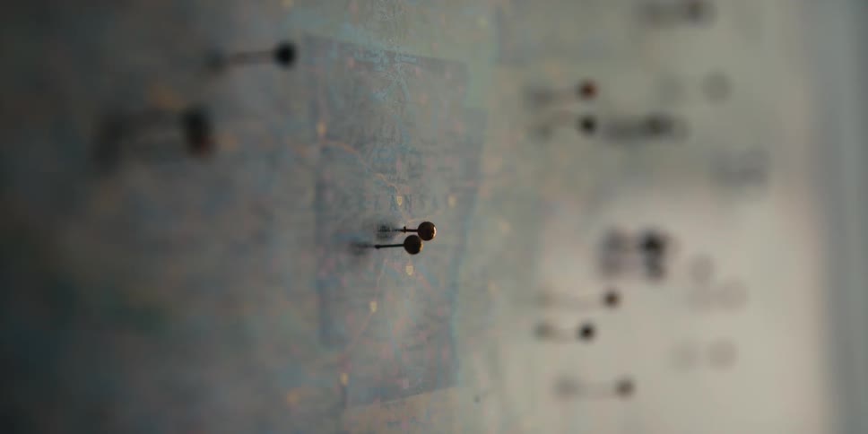Pushpins form a scattered pattern on a wall