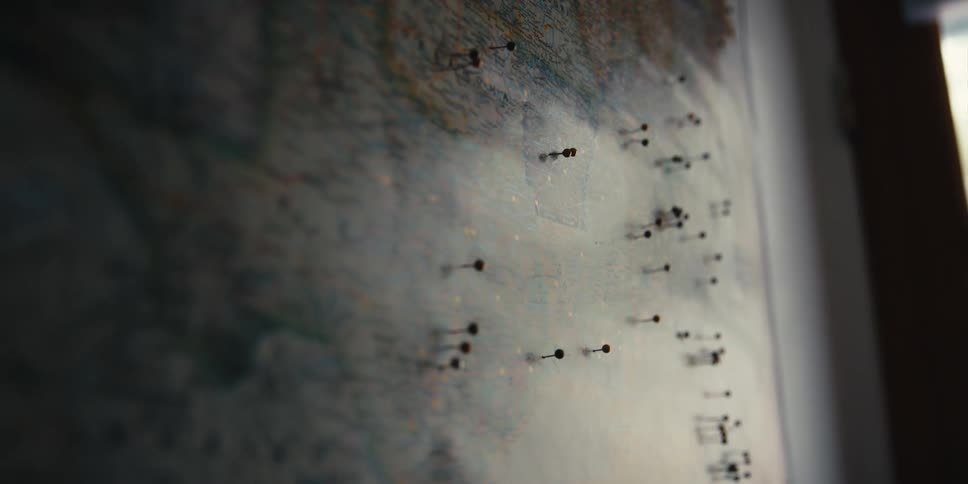 A view of a map on the wall with pins in it