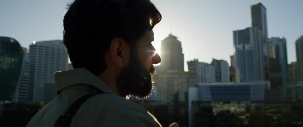 Man takes a picture of the city buildings with a camera on a sunny day