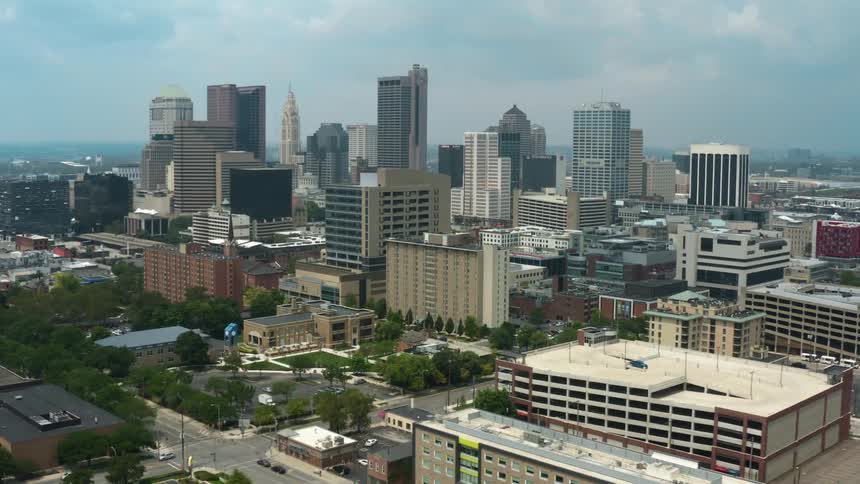 Cars travel on the streets in the city as skyscrapers sit nearby
