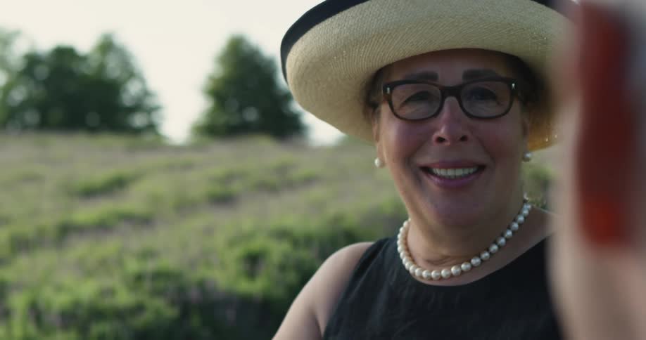 A woman smiles as she talks to someone outdoors