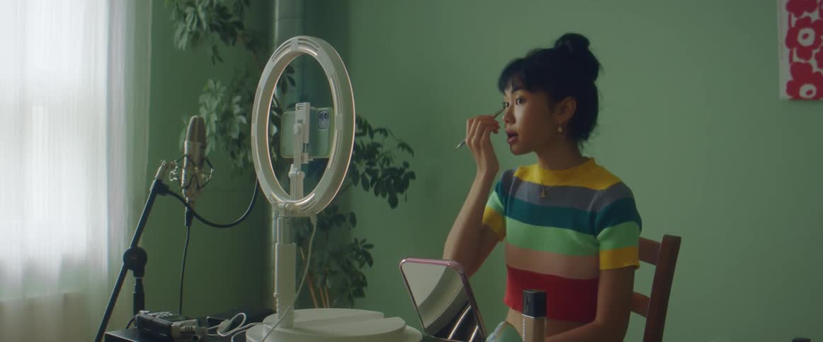 A woman putting on makeup in a room