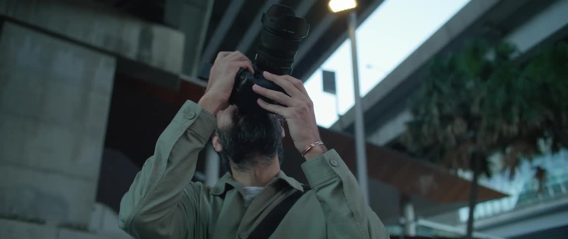 A man with a camera outdoors taking photos