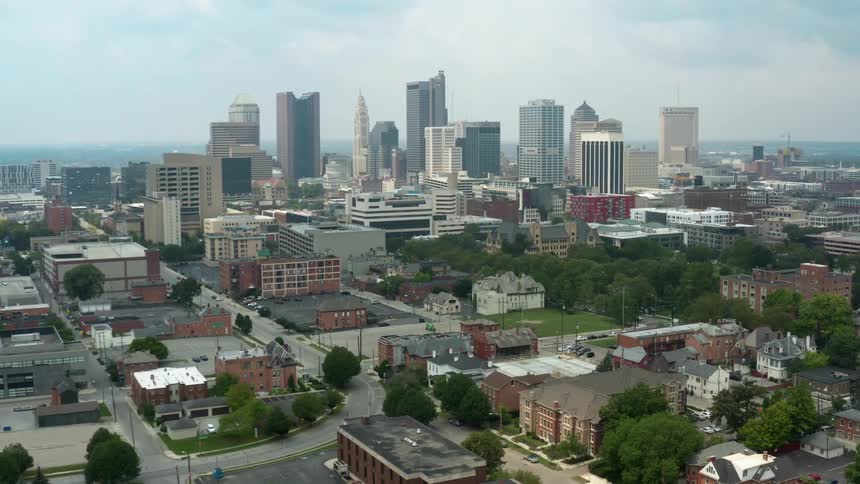 An aerial view of buildings and tall skyscrapers in a city on a summer day