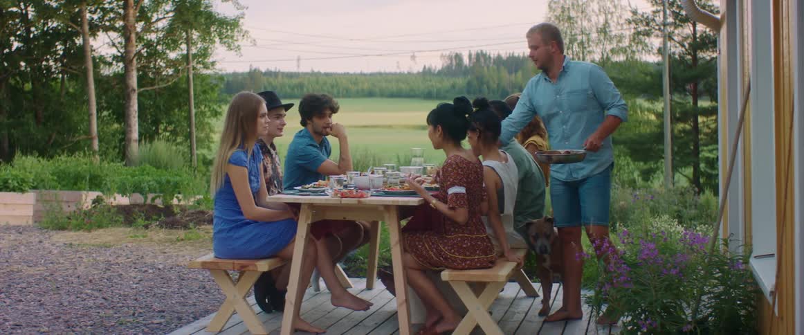 A man is serving food to people in his yard