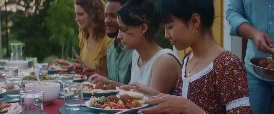 A view of people all eating together outdoors