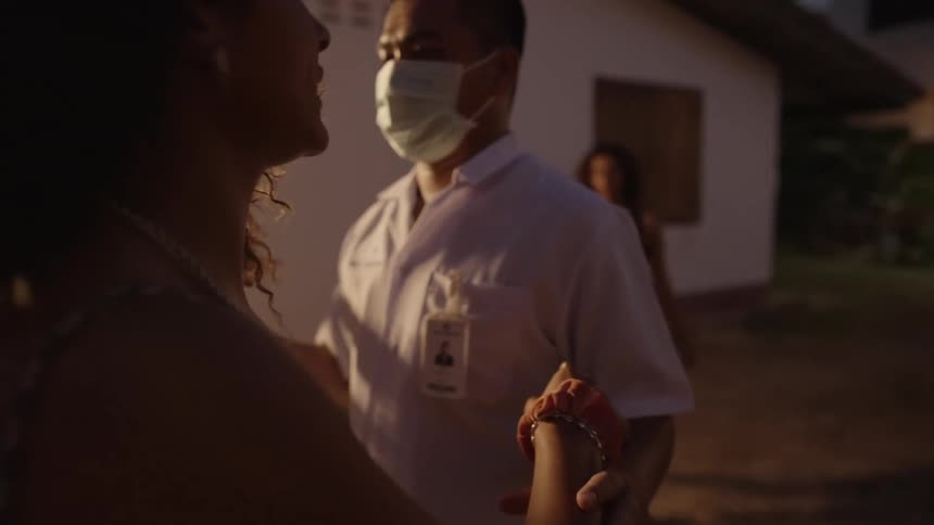 A view of people talking with a paramedic outdoors