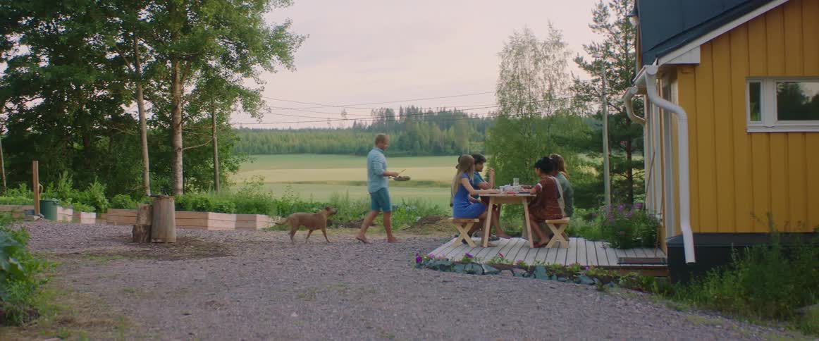 A group of people sitting outdoors having food