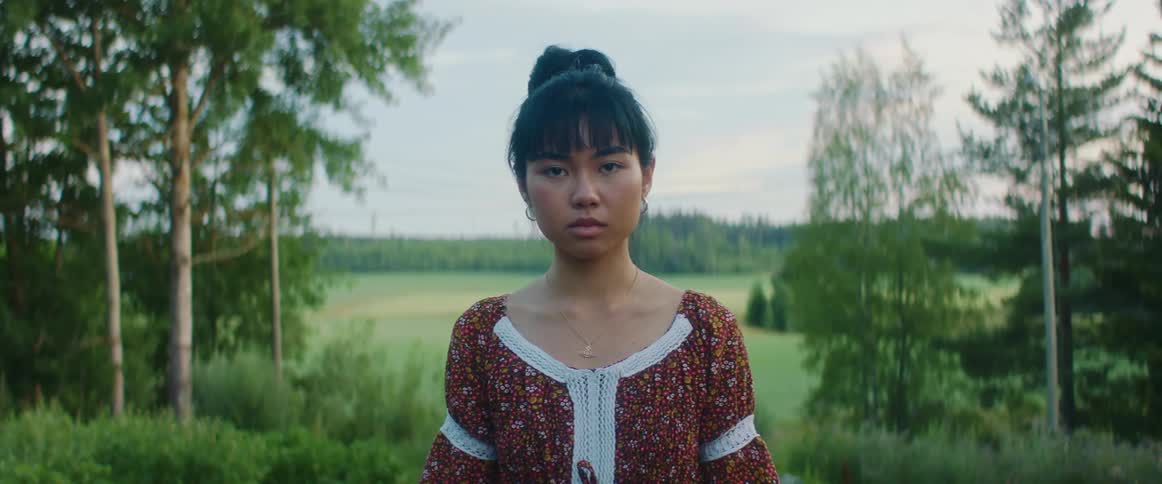 A woman standing in front of a nature background