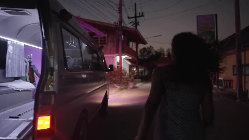 A woman runs past an open ambulance