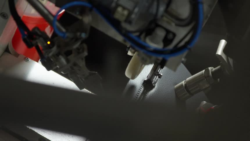 A close up of a robot stitching