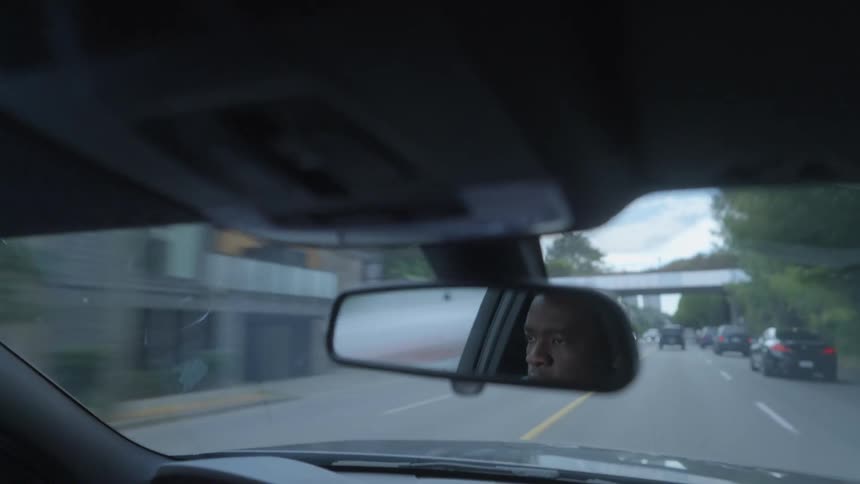 A man is driving a car through the city streets