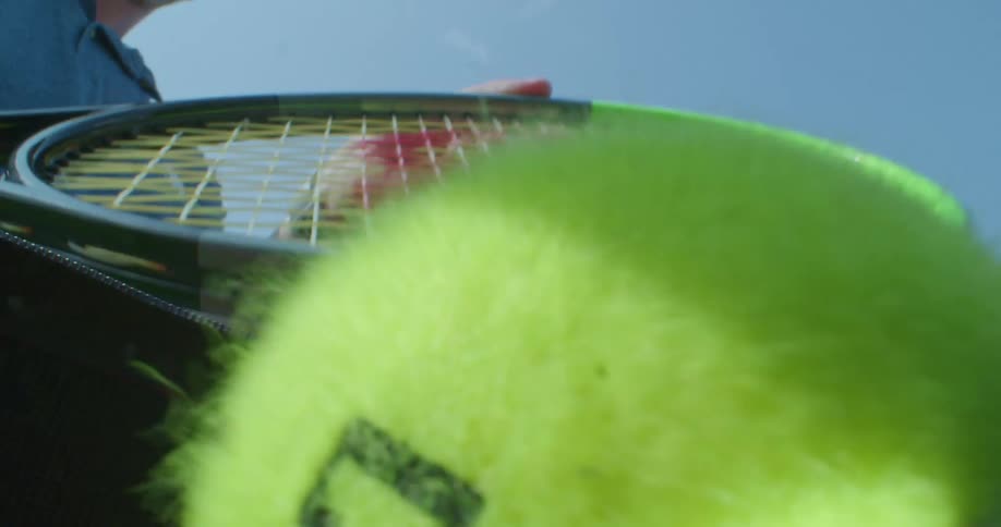 Tennis player with cap and shirt puts tennis balls in bag