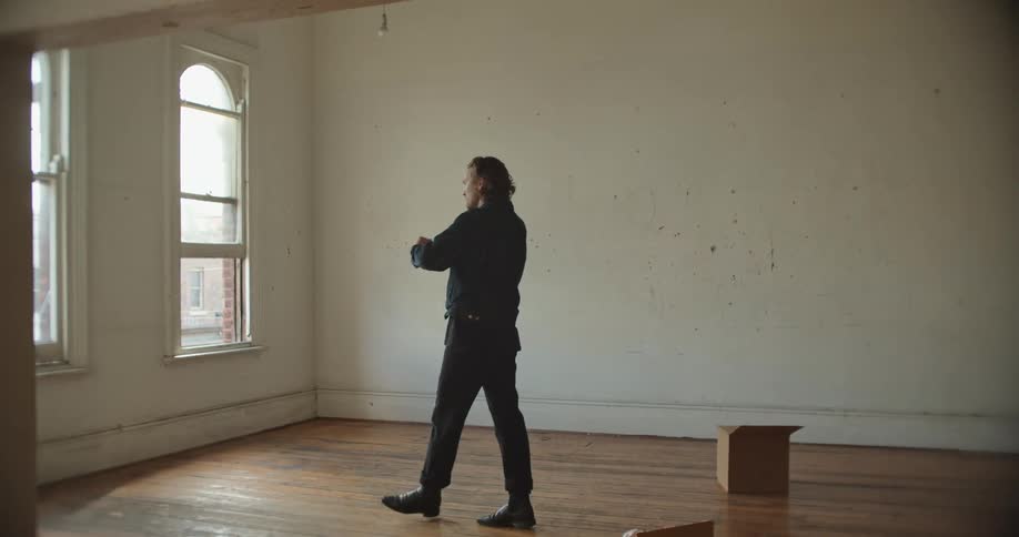 A man is talking on a cell phone in an empty apartment building