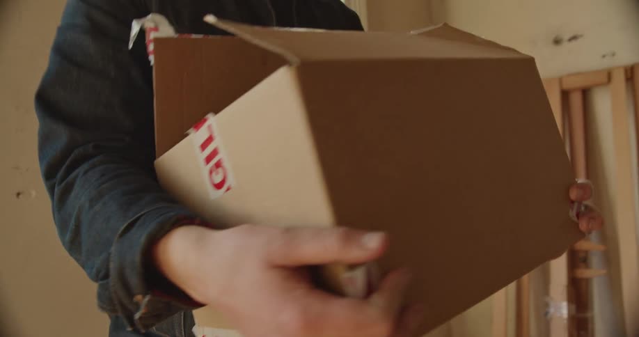 A view of a man holding a box in a room