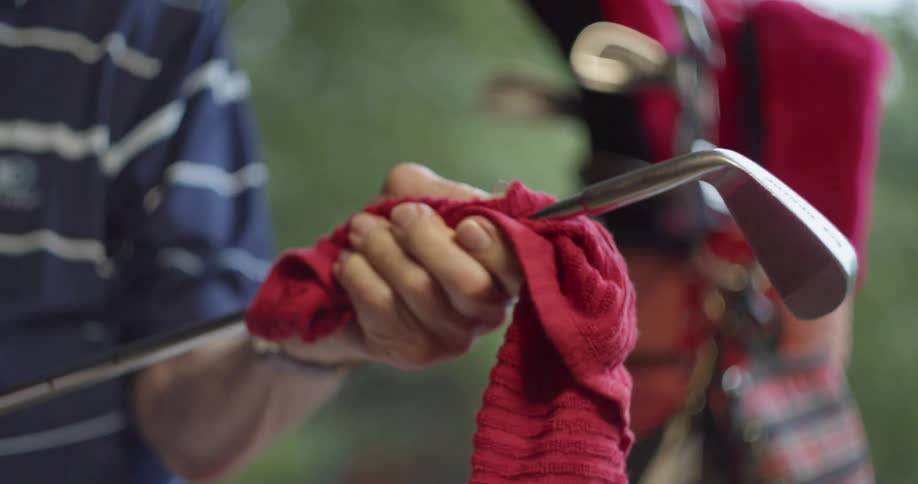A person cleaning a golf club