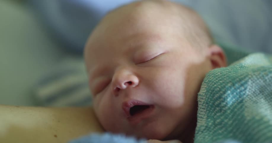 Newborn baby with blue blanket sleeps