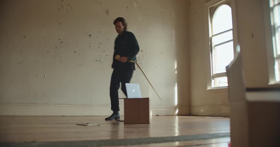 A man measures the window in the room