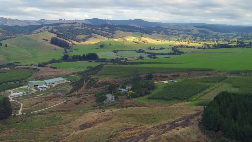 A landscape with hills and trees with the sky and clouds in the background