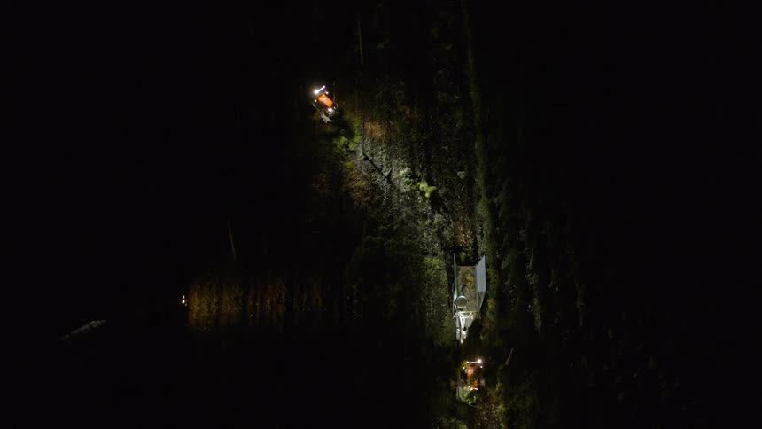 The farm vehicles are working the fields at night