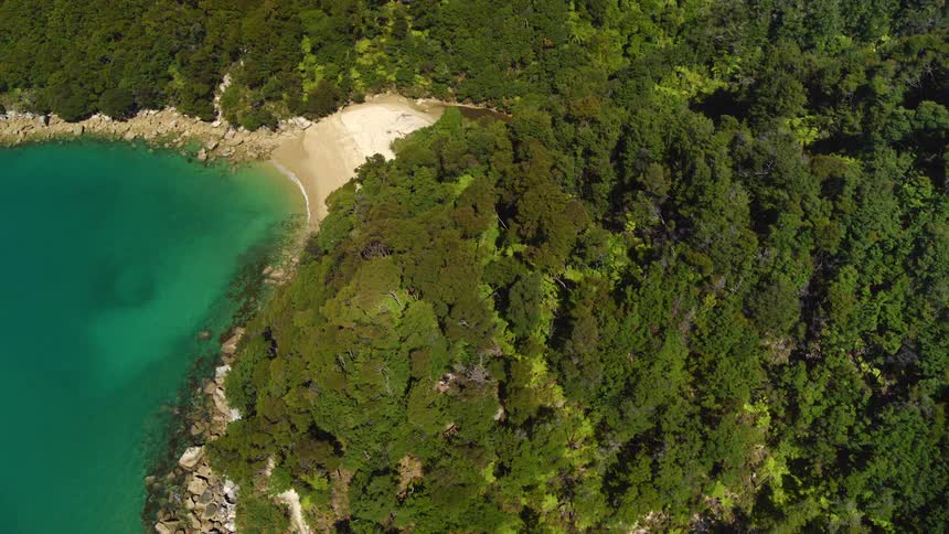 The small beach leads into the hills of the island