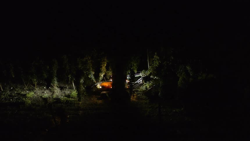 An aerial view of a tractor driving on a farm
