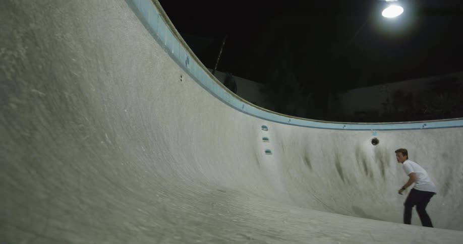A young man is skating on a skateboard ramp
