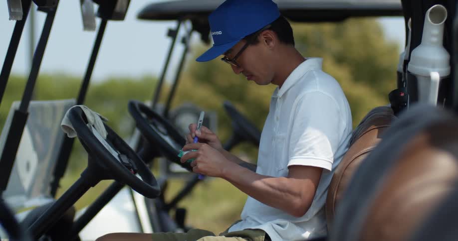 A man keeping score in a golfing cart on a summer day