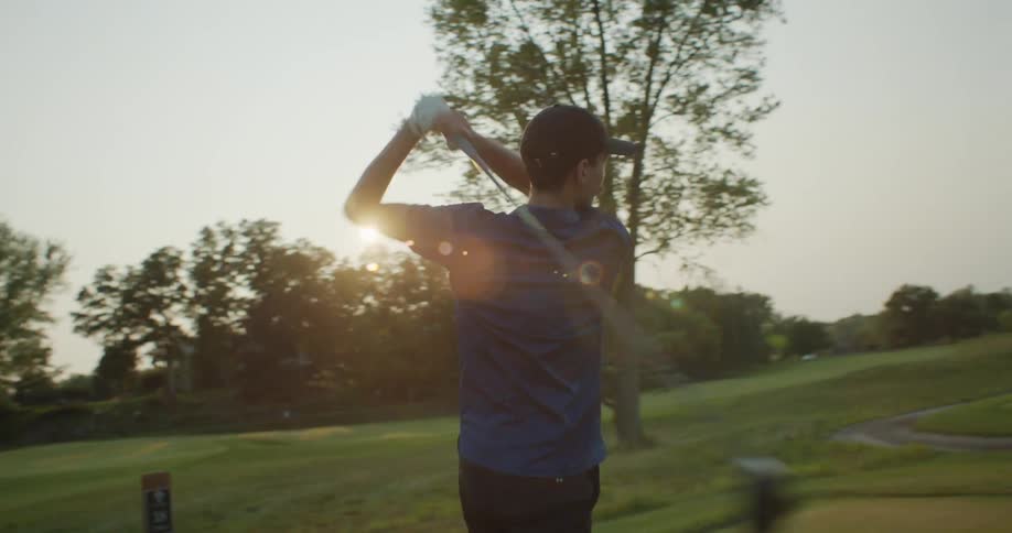 A man swings his golf club as he golfs on a course
