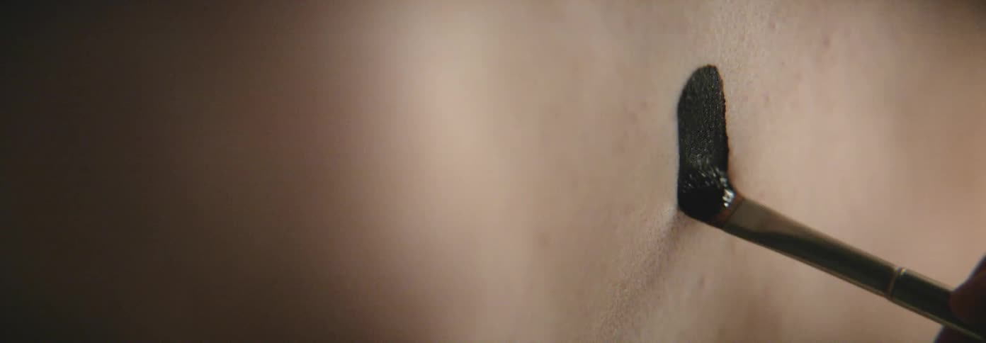 A person is painting someones skin