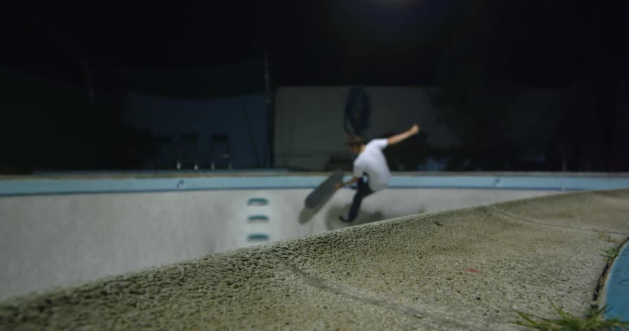 A man falls off the skateboard while doing a jump