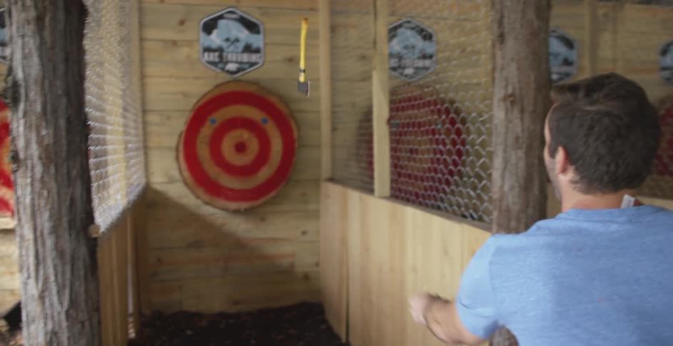 A man throws an ax at a target at an ax throwing range