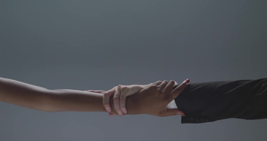 A man and woman hold their arms straight out and pull on each others wrist