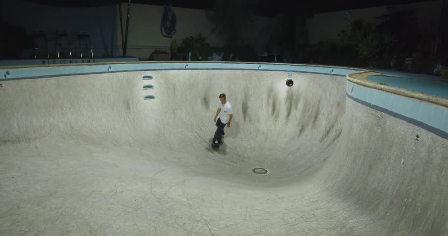 A man skateboarding around in a pool
