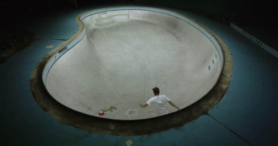 A man is skateboarding at a skatepark at night