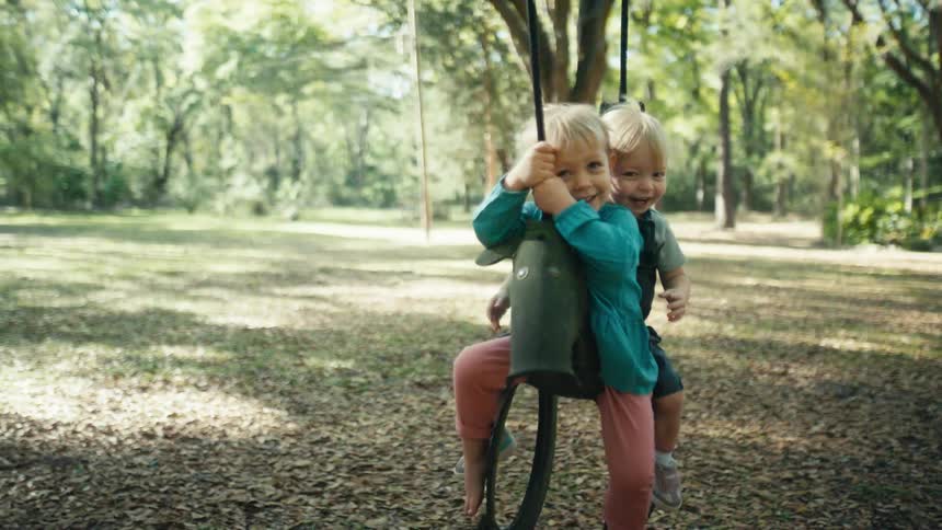 Two toddlers are playing at the park in spring