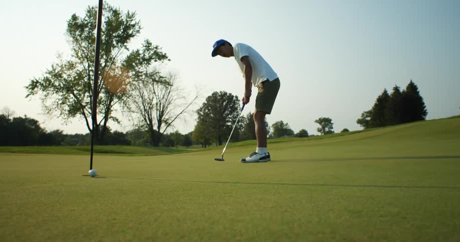 A man is playing golf outdoors in the spring