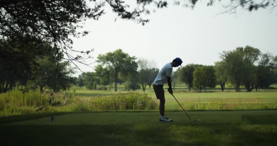 A man holding a golf club addresses the ball and plans his shot