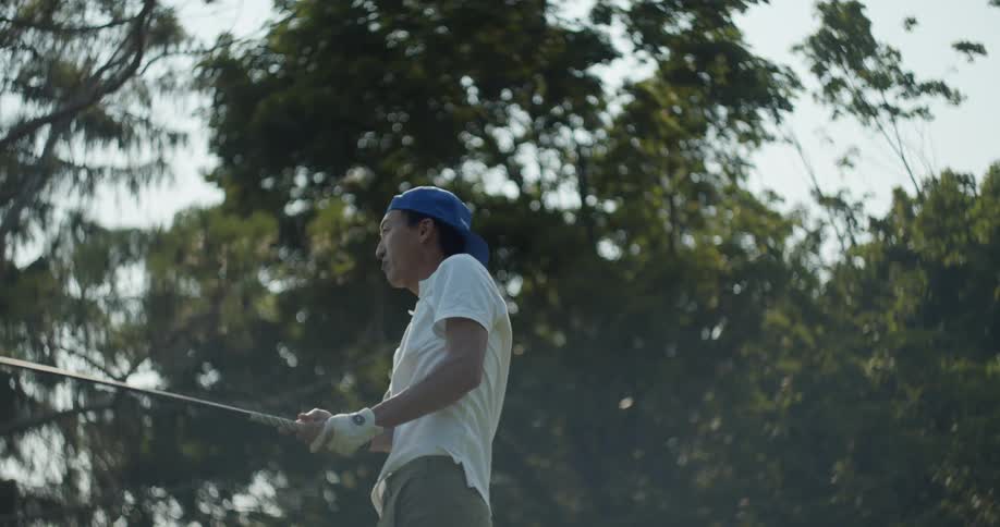 A man that is swinging a golf club on a golf course