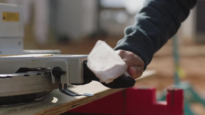 Person sprays lysol spray on machine handle and wipes it with disposable cloth