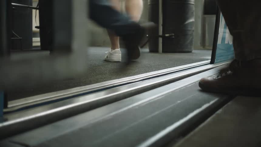 Train doors open and a crowd of people walk onto the train platform