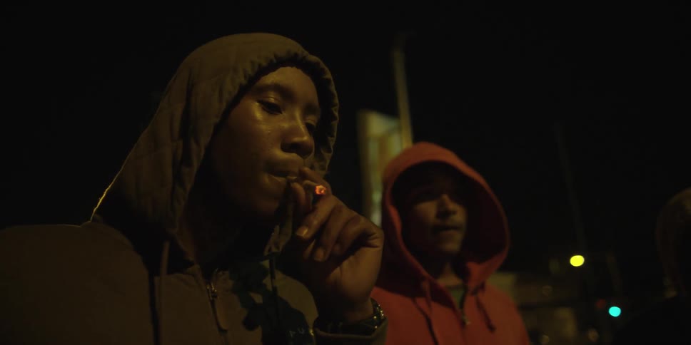 Two men in hoodies outside at night