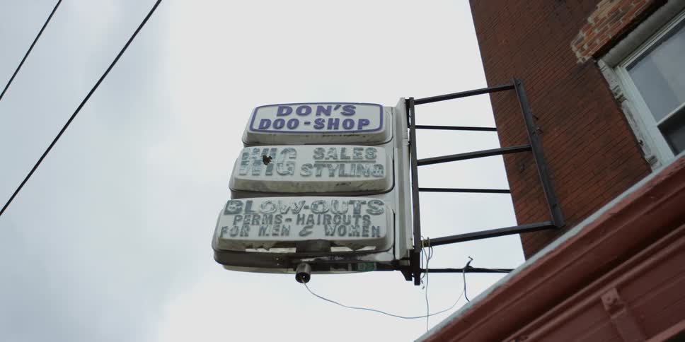 Three signs are on the side of a building
