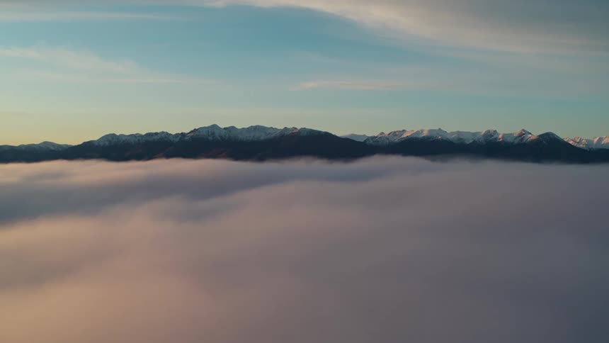 A mountain range with snow and ice with the sky and clouds in the background