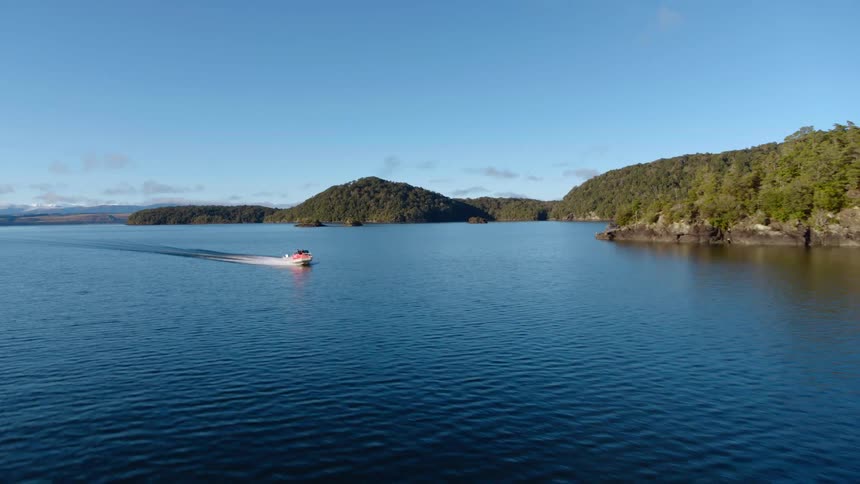 People are traveling fast across a lake in a speed boat